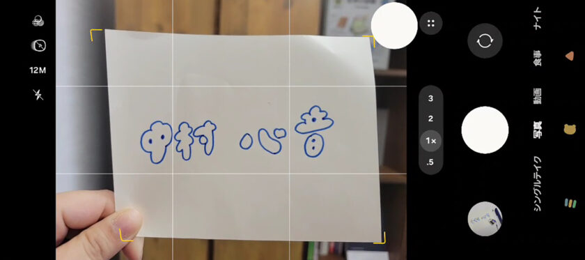 「中村心音」と手書き文字で書かれた紙を持ちそれを撮影している様子